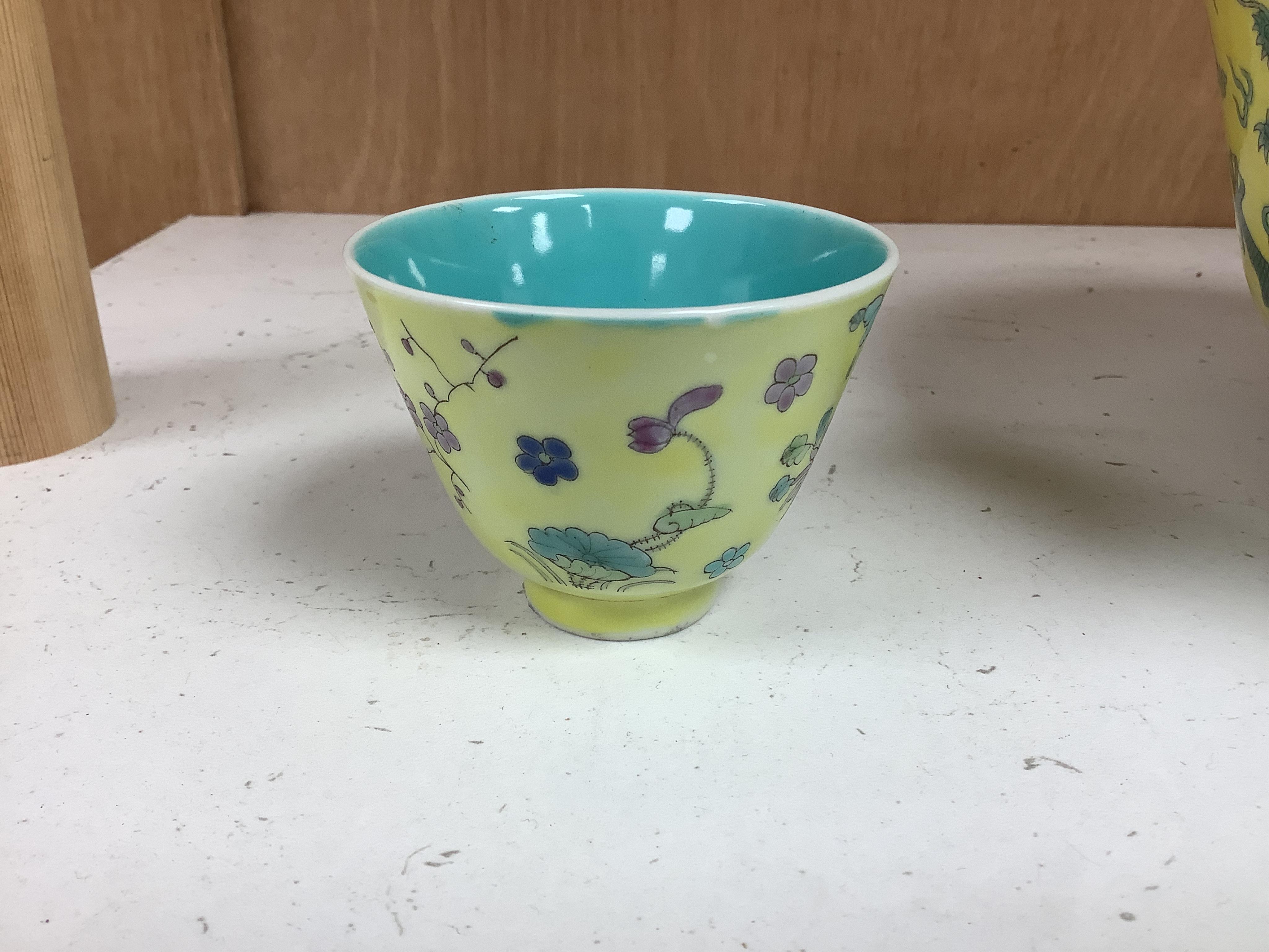 A Chinese yellow ground 'dragon' bowl, probably late Qing dynasty, and a similar floral cup, bowl 9cm high, 18.5cm diameter. Condition - bowl has a large section restored